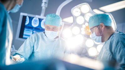 Three surgeons in a surgery room.