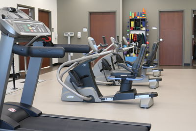 Physical Therapy gym showing a treadmill and exercise bikes